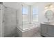 Modern bathroom with a glass shower, soaking tub, and gray tiled floors at 8847 Bel Meadow Way, Trinity, FL 34655