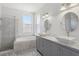 Bright bathroom featuring a soaking tub, frameless shower, double vanity, and marble counters at 8847 Bel Meadow Way, Trinity, FL 34655