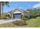 Two-car garage with blue door framed by lush landscaping on a sunny day at 8847 Bel Meadow Way, Trinity, FL 34655