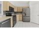 Practical kitchen with wood cabinets, sleek stainless steel appliances, and ample counter space at 8847 Bel Meadow Way, Trinity, FL 34655