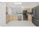Functional kitchen features wood cabinets, stainless steel appliances, and tile flooring for modern convenience at 8847 Bel Meadow Way, Trinity, FL 34655
