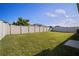 A lush backyard with a well-maintained lawn and a tall white fence, offering a perfect space for outdoor activities and privacy at 1506 Climbing Dayflower Dr, Ruskin, FL 33570