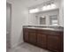 The bathroom features a double vanity with granite countertops and dark wood cabinets, complemented by a large mirror and neutral tile at 1506 Climbing Dayflower Dr, Ruskin, FL 33570