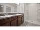 Bathroom with a double vanity featuring granite countertops, a framed mirror, and a separate walk-in shower with white tile at 1506 Climbing Dayflower Dr, Ruskin, FL 33570