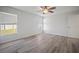 Bedroom features soft gray tones, a ceiling fan, light wood-look floors, creating a peaceful and inviting space at 1506 Climbing Dayflower Dr, Ruskin, FL 33570