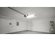 Clean, spacious garage with ample lighting, featuring a sealed concrete floor and white walls at 1506 Climbing Dayflower Dr, Ruskin, FL 33570