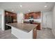 Spacious kitchen boasts an island with granite countertops, stainless steel sink and matching dark wood cabinets at 1506 Climbing Dayflower Dr, Ruskin, FL 33570