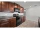 Modern kitchen with dark wood cabinets, black appliances, and granite countertops, perfect for cooking at 1506 Climbing Dayflower Dr, Ruskin, FL 33570