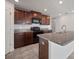 Well-equipped kitchen featuring dark wood cabinets, granite countertops, stainless steel sink, and black appliances at 1506 Climbing Dayflower Dr, Ruskin, FL 33570
