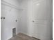 Small, simple laundry room featuring tile floors, a metal shelf, and hookups for a washer and dryer at 1506 Climbing Dayflower Dr, Ruskin, FL 33570