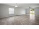 Bright, open living room with tile floors, a large window, and sliding glass doors to the backyard at 1506 Climbing Dayflower Dr, Ruskin, FL 33570