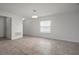 Bright, open living room with tile floors, a large window, and two doorways leading to other rooms at 1506 Climbing Dayflower Dr, Ruskin, FL 33570