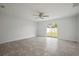 Bright, airy living room with tile flooring, ceiling fan and sliding glass door to the backyard at 1506 Climbing Dayflower Dr, Ruskin, FL 33570