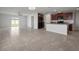 Open-concept living room with tile flooring, with a view of the kitchen and sliding glass doors to the backyard at 1506 Climbing Dayflower Dr, Ruskin, FL 33570