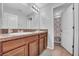 Modern bathroom with double sinks, granite countertops, brown cabinets, tile floors, and ample lighting at 10612 Strawberry Tetra Dr, Riverview, FL 33578