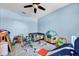 A playroom offers plenty of space for toys and fun activities, complete with blue walls and a ceiling fan at 10612 Strawberry Tetra Dr, Riverview, FL 33578