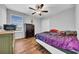 Cozy bedroom featuring a ceiling fan, a window with blinds, wood floors, and simple decor at 10612 Strawberry Tetra Dr, Riverview, FL 33578