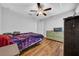 This well-lit bedroom features hardwood floors, a ceiling fan, a closet, and neutral paint at 10612 Strawberry Tetra Dr, Riverview, FL 33578