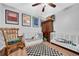 Bright Bedroom featuring hardwood floors, two cribs, a rocking chair, and fun artwork at 10612 Strawberry Tetra Dr, Riverview, FL 33578