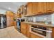 Kitchen with stainless steel appliances, tile backsplash, wood cabinets, and granite countertops at 10612 Strawberry Tetra Dr, Riverview, FL 33578