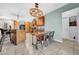 A stylish kitchen boasts wood cabinetry, an island with bar seating, and a dining table under an industrial-chic chandelier at 10612 Strawberry Tetra Dr, Riverview, FL 33578