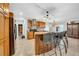 Kitchen with wooden cabinets, granite countertops, tile flooring, and a center island with bar stools at 10612 Strawberry Tetra Dr, Riverview, FL 33578