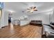 A hardwood floor living room on the second story is lit with a ceiling fan and offers comfortable, black leather seating at 10612 Strawberry Tetra Dr, Riverview, FL 33578