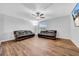 The living room features hardwood floors, a ceiling fan, and two matching black leather sofas for comfortable seating at 10612 Strawberry Tetra Dr, Riverview, FL 33578