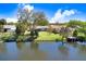 Lush backyard with grassy lawn, bordered by mature trees, and a private dock extending onto the water at 10790 92Nd St, Seminole, FL 33777