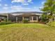 Beautiful backyard featuring a screened lanai, lush green lawn, and professional landscaping at 11248 Juglans Dr, Odessa, FL 33556