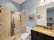 Bathroom with a glass enclosed shower, stone vanity, framed mirror, and neutral color palette at 11248 Juglans Dr, Odessa, FL 33556