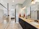 Modern bathroom featuring a large shower with dark trim, double vanity and marble countertop at 11248 Juglans Dr, Odessa, FL 33556