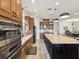 Gourmet kitchen with wooden cabinets, granite countertops, stainless steel appliances, and large center island at 11248 Juglans Dr, Odessa, FL 33556