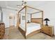Spacious main bedroom featuring a four-poster bed, neutral decor, and ensuite access at 11248 Juglans Dr, Odessa, FL 33556