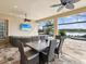 Covered outdoor patio with a dining table, ceiling fans, and a view of the pool and the lake at 11248 Juglans Dr, Odessa, FL 33556