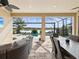 Outdoor patio features a lakeside view, comfortable furniture, screened in enclosure, and ceiling fans at 11248 Juglans Dr, Odessa, FL 33556