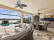 An expansive outdoor patio with ceiling fans, comfortable furniture, lake view and an outdoor kitchen at 11248 Juglans Dr, Odessa, FL 33556