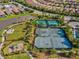 Aerial view of tennis and pickleball courts with playground in well-maintained community with mature landscaping at 11248 Juglans Dr, Odessa, FL 33556