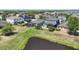 Lovely backyard with lush green lawn, a screened-in patio, and a partial view of the tranquil pond at 11327 Emerald Shore Dr, Riverview, FL 33579
