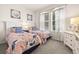 Bright bedroom with two twin beds featuring floral bedding, white dressers, and natural light from the window at 11327 Emerald Shore Dr, Riverview, FL 33579