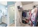 Walk-in closet adjacent to a bathroom, featuring ample shelving and storage space for clothing and accessories at 11327 Emerald Shore Dr, Riverview, FL 33579