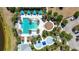 Aerial view of community pool showcasing cabanas, splashpad, and ample lounge seating near the main pool at 11327 Emerald Shore Dr, Riverview, FL 33579