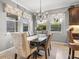 Elegant dining room with a dark wood table, seating for six, and natural light streaming through the windows at 11327 Emerald Shore Dr, Riverview, FL 33579