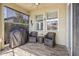 Relaxing covered patio includes wood-look tile flooring, seating, and grill at 11327 Emerald Shore Dr, Riverview, FL 33579