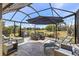 Relaxing screened-in patio with comfortable seating, outdoor dining set, and serene lake views at 11327 Emerald Shore Dr, Riverview, FL 33579