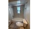 Clean, all white bathroom featuring an over-the-tub shower, toilet, and patterned window at 1200 Abbey Crescent Ln, Clearwater, FL 33759