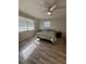 Cozy bedroom with two windows, a ceiling fan, wood floor, and comfortable bed, perfect for relaxation at 1200 Abbey Crescent Ln, Clearwater, FL 33759