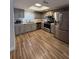 Bright kitchen with stainless steel appliances and grey cabinetry and wood look flooring at 1200 Abbey Crescent Ln, Clearwater, FL 33759
