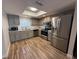 Updated kitchen with stainless steel appliances, gray cabinets and modern lighting at 1200 Abbey Crescent Ln, Clearwater, FL 33759