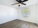 A well-lit bedroom featuring wood-look floors, a large window, and fresh white walls at 1209 W Camellia Dr, Brandon, FL 33510